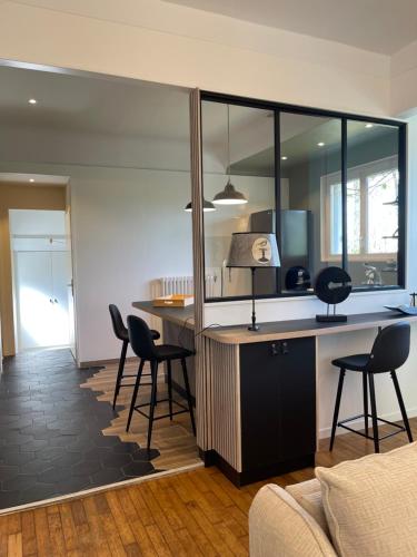 a kitchen with a desk and chairs in a room at Hôtel du Golf Saint Lazare in Limoges