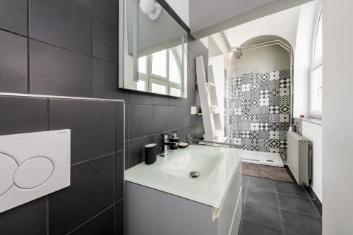 a bathroom with a white sink and a mirror at Apartment Napoleon in Ljubljana