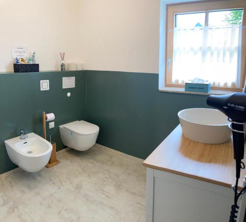 a bathroom with two sinks and a toilet and a window at Franz Josef am Ratschenberg in Eisenberg an der Pinka