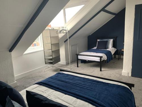 a attic bedroom with two beds and a window at Windsor 4 - Spacious beautiful 4 bdrm maisonette nr Ncle free wifi free parking in Gateshead