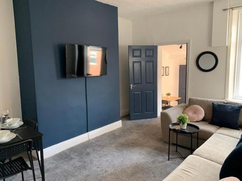 a living room with a couch and a blue wall at Windsor 4 - Spacious beautiful 4 bdrm maisonette nr Ncle free wifi free parking in Gateshead