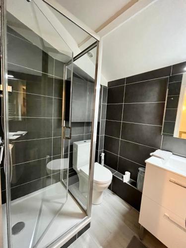 une salle de bain avec toilettes et douche en verre dans l'établissement Deauville, maison au coeur de la ville, à Deauville