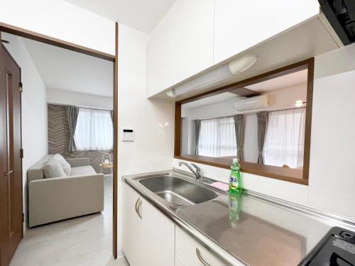 a kitchen with a sink and a mirror at Dio Higashi Shinsaibashi in Osaka