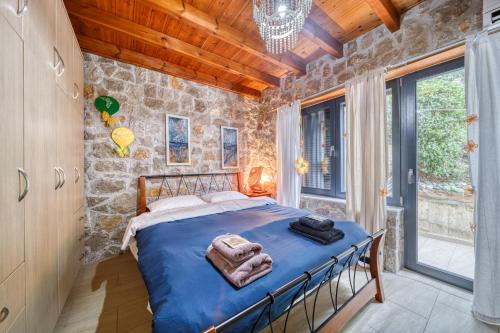 a bedroom with a bed and a stone wall at Magical view, Villa Asproneri, Kamena Vourla in Kamena Vourla