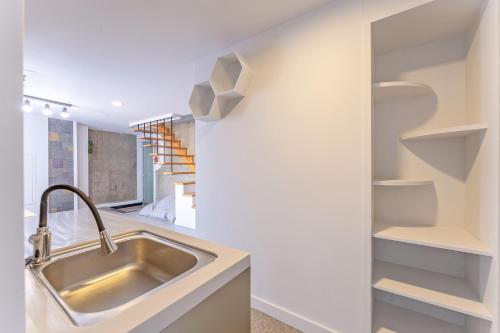 a kitchen with a sink and a wall with shelves at Hinokki Haesuzzim Resort in Geoje 
