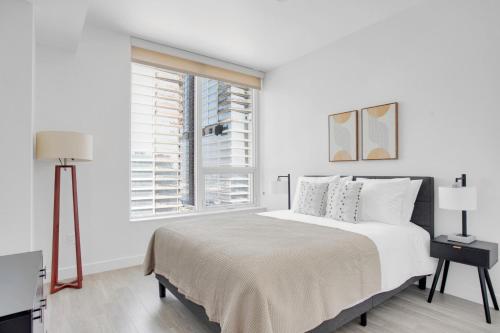 a white bedroom with a large bed and a window at Downtown 1BR w Pool Jacuzzi Gym nr 110 LAX-836 in Los Angeles