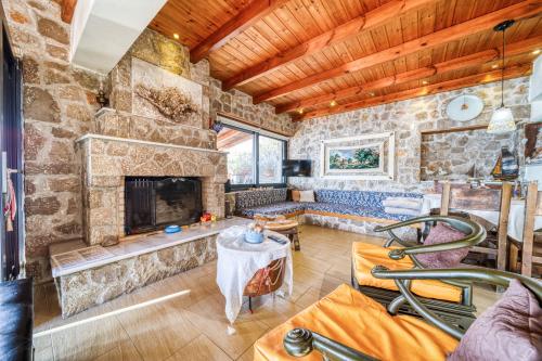 a living room with a fireplace and a stone wall at Magical view, Villa Asproneri, Kamena Vourla in Kamena Vourla