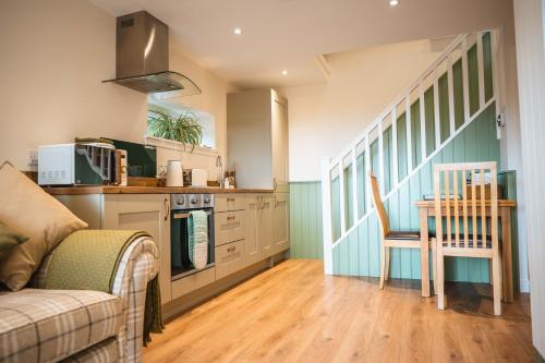 a kitchen with a couch and a table in a room at Taighsona Bothy, Speyside - amazing views! in Archiestown