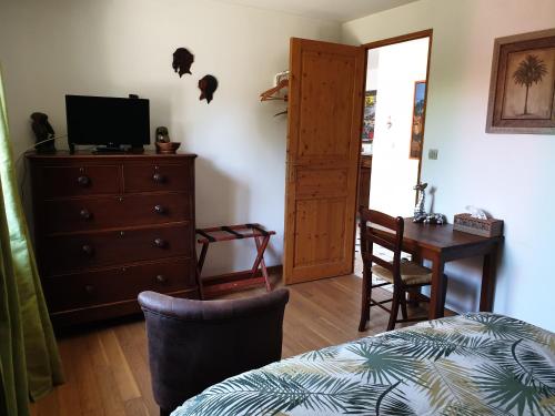 une chambre avec un lit, une commode et un bureau dans l'établissement LA MAISON DE NACRE, à Douvres-la-Délivrande