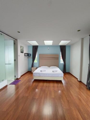 a large bedroom with a bed and a wooden floor at Dear Dino Villa Cameron Highlands in Cameron Highlands