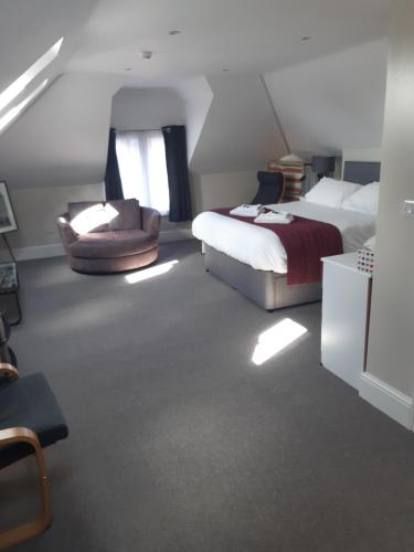 a bedroom with a bed and a chair and a couch at The Russet House in King's Lynn