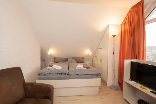 małą sypialnię z łóżkiem i telewizorem w obiekcie Kettelhack Appartement -K4a- im KETTELHACK w mieście Langeoog