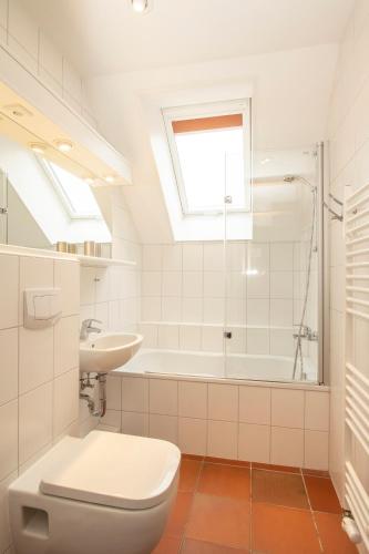 a bathroom with a toilet and a sink and a tub at Kettelhack Appartement -K4a- im KETTELHACK in Langeoog