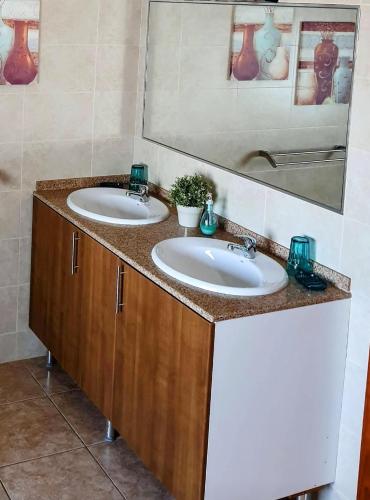 a bathroom with two sinks and a mirror at Villa Feliza in Güime