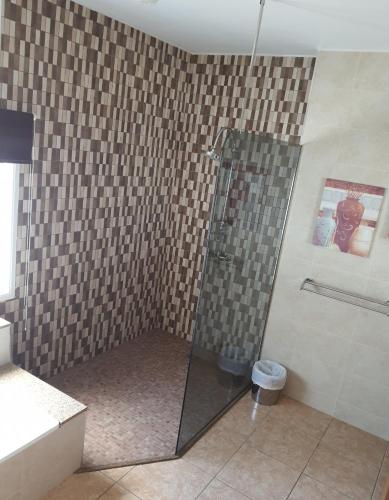 a shower with a glass door in a bathroom at Villa Feliza in Güime