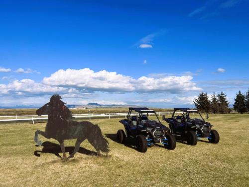 a statue of a horse and two atvs in a field at Ármót Guesthouse in Hvolsvöllur