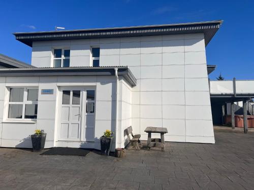 a white building with a bench in front of it at Ármót Guesthouse in Hvolsvöllur