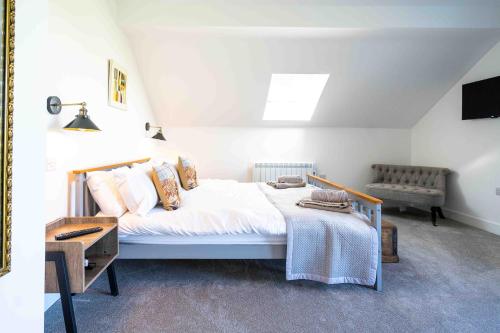 a bedroom with a bed and a table and a chair at Fletland Mill and Holiday Hamlet - 18th century watermill, in stunning location near Stamford in Stamford