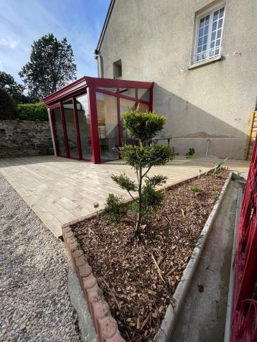 a house with a red glass door on a patio at Le Marlo in Poilley