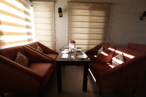 a living room with two red couches and a table at HOTEL JS SOUVENIR in Dehradun