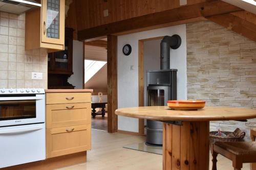 eine Küche mit einem Holztisch und einem Herd in der Unterkunft Appartement Chez l'apiculteur in Travers