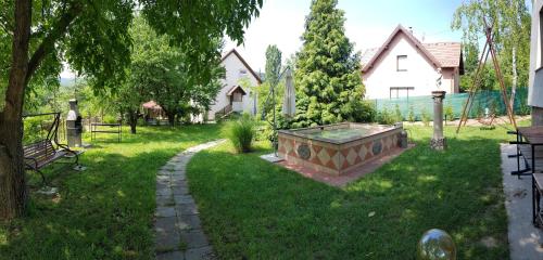 um quintal com uma grande banheira na relva em Hill View Holiday House nearby Budapest with AC & Pool em Pilisszentiván