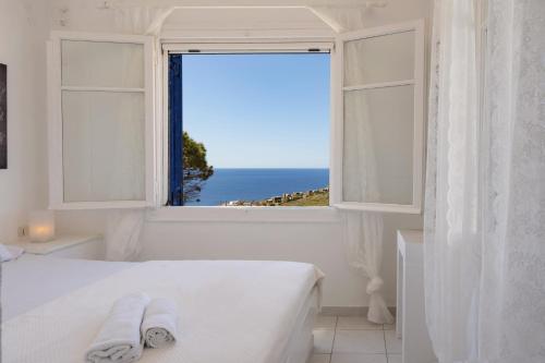 a bedroom with a window with a view of the ocean at Konstantinos and Eleni's Apartment in Koundouros