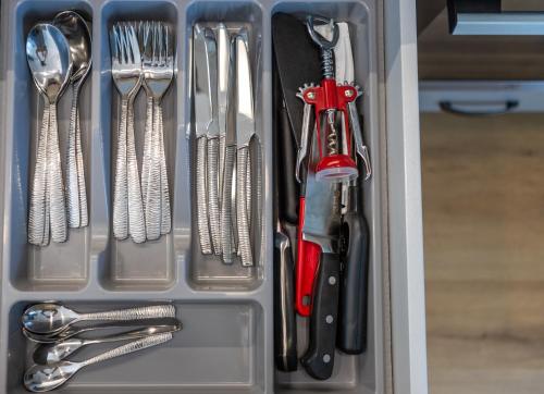 a drawer filled with utensils and utensils at GENIO 7 apartamentai in Palanga
