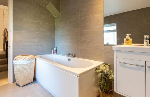 Beautiful 3 Bedroom Townhouse في هاروغايت: حمام مع حوض أبيض ومغسلة