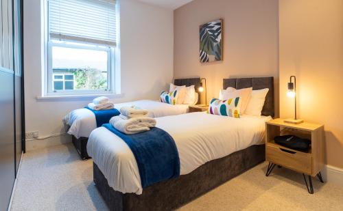 1 dormitorio con 2 camas y ventana en Beautiful 3 Bedroom Townhouse en Harrogate