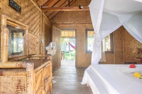 a bedroom with a bed in a wooden house at Abdi Fantastik in Gili Islands