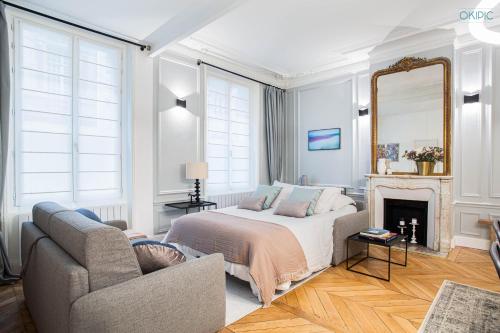 une chambre avec un lit, un canapé et un miroir dans l'établissement King Size beds - Zen Monceau, à Paris