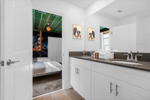 - une salle de bains blanche avec lavabo et une chambre dans l'établissement 9 Bedroom 5 Bathroom Storey Lake 4276 Pw, à Kissimmee