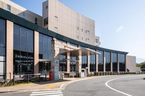 a large building with a road in front of it at Enakyo Onsen Hotel Yuzuriha in Ena