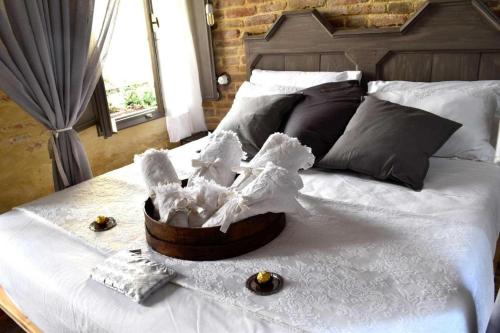 a bed with a basket of white linen and a window at Dimora 421 Apartsuite in Chioggia
