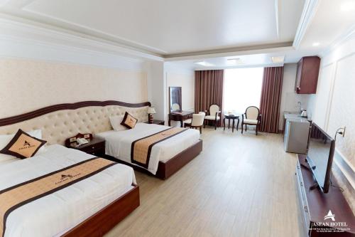 a hotel room with two beds and a table at Asean Hotel in Hải Dương