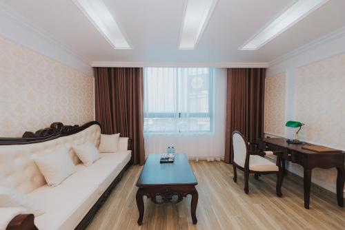 a living room with a white couch and a piano at Asean Hotel in Hải Dương