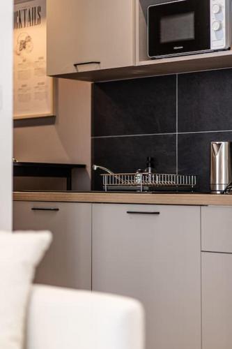 une cuisine avec un comptoir avec un micro-ondes dans l'établissement Bliss - Résidence Hestia, à Saint-Étienne