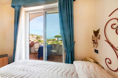 1 dormitorio con cama y vistas al océano en Hotel Terme Don Pepe, en Isquia
