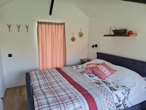 a bed with a blanket on it in a bedroom at 't Hûske in Venhorst