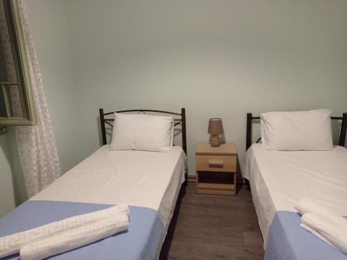 dwa łóżka siedzące obok siebie w pokoju w obiekcie Villa Lidi w mieście Stavros