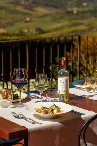 a table with a plate of food and a bottle of wine at Tenuta di Artimino member of Meliá Collection Wine Resort in Artimino