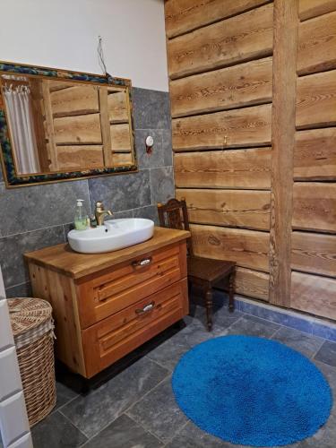 a bathroom with a sink and a wooden wall at Sosnowy Domek in Harasiuki