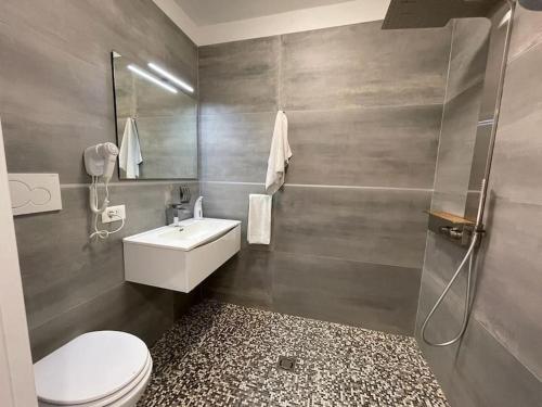 a bathroom with a toilet and a sink and a shower at Baja Moderno Trilocale vicino al mare in Bibione