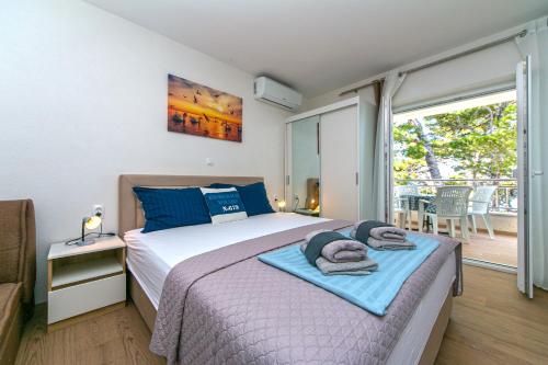ein Schlafzimmer mit einem Bett mit Handtüchern darauf in der Unterkunft Apartmani Jakiruša in Brela