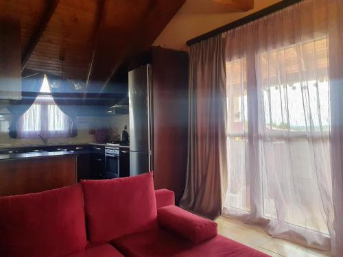 a living room with a red couch and a kitchen at Attic Paradise in Flogita