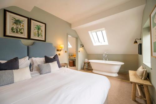 a bedroom with a large white bed and a bath tub at The Bottle & Glass Inn - Book All 3 Rooms in Henley on Thames