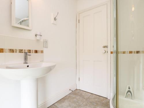 uma casa de banho com um lavatório e um chuveiro em Plum Cottage em Colebrooke
