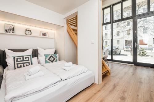 a white bed in a room with a large window at Stylish New Cube Loft by Berlin-Wall-Apartments in Berlin