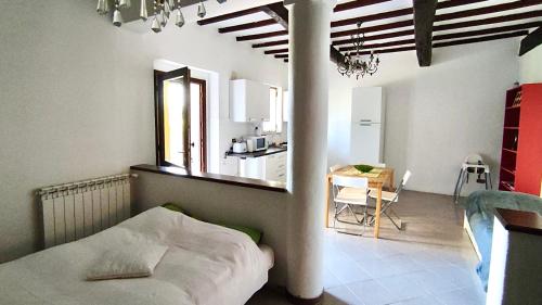 um quarto com uma cama e uma cozinha com uma mesa em Poggio alla Pietra 26 em Porrona